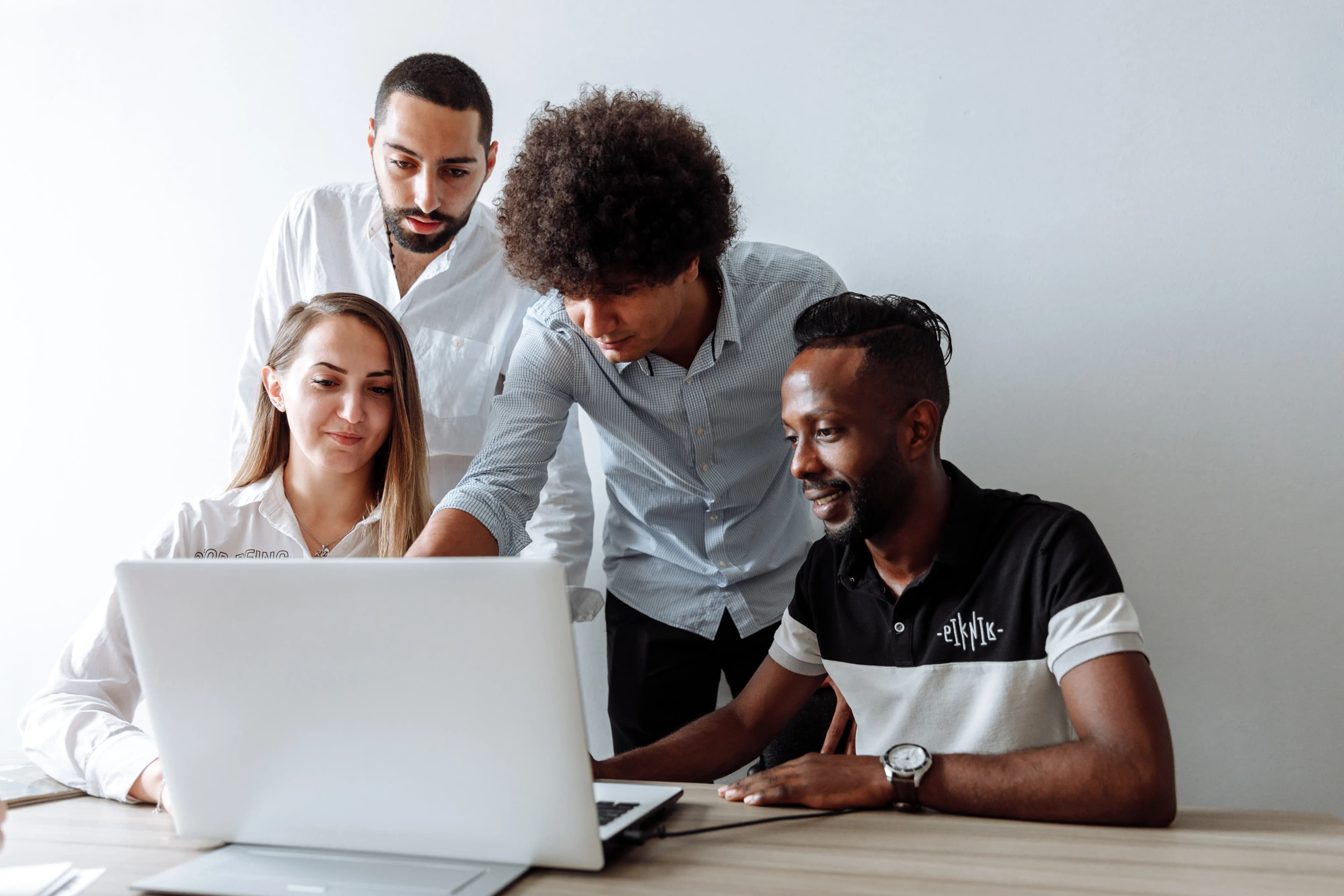 Small business team members working together on laptops around an office table