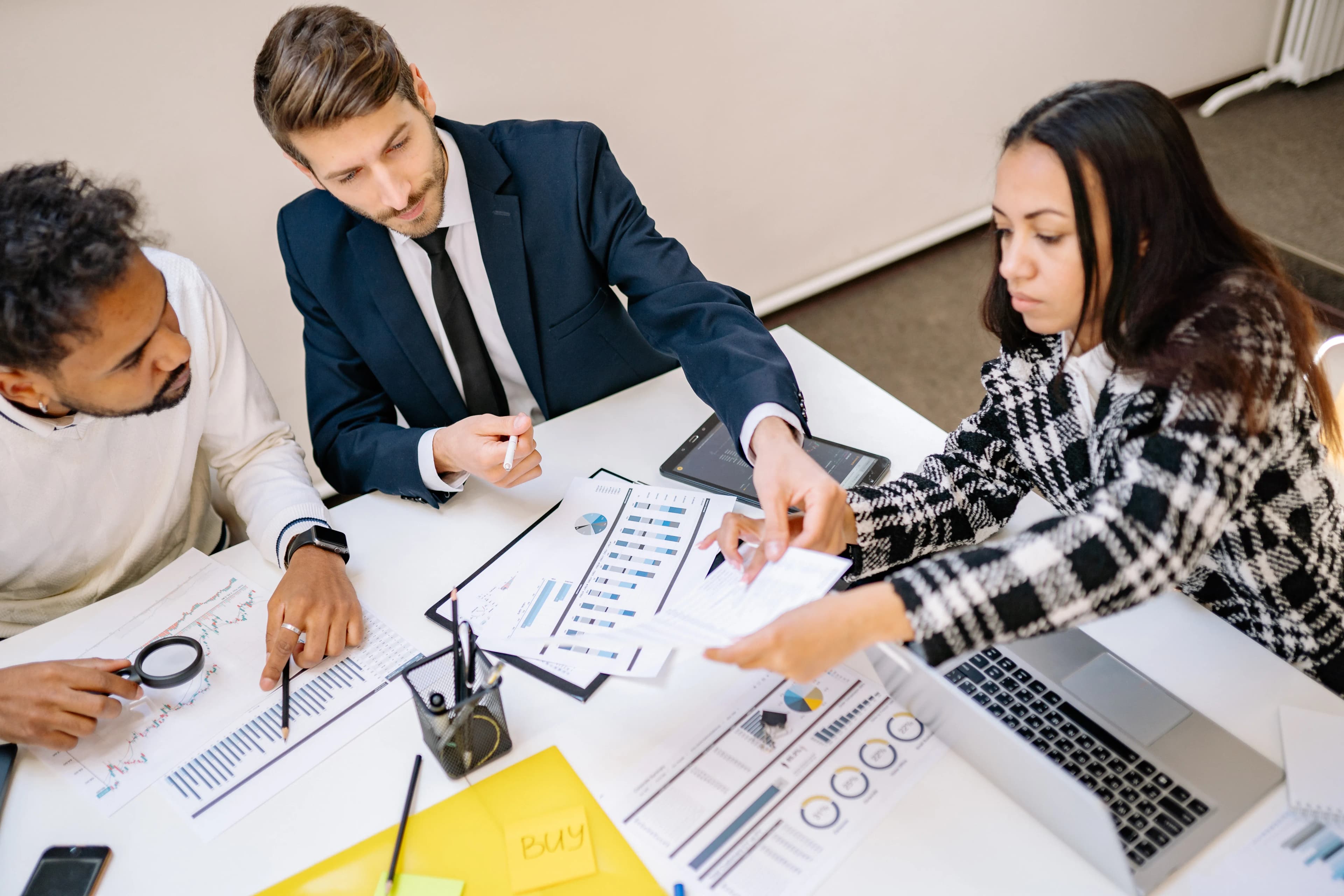 A business team reviewing charts and documents around a table.